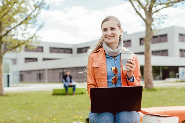 Studerande med kaffe och laptop framför universitetshuset — Stockfoto