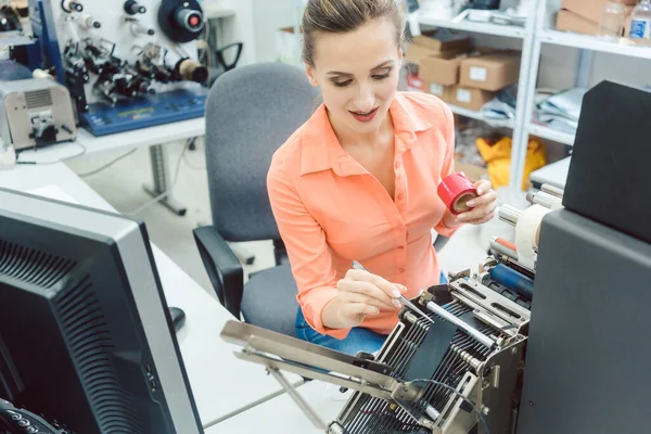 Mujer trabajando en máquina de impresión de etiquetas — Foto de Stock