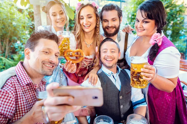 Wesoła grupa przyjaciół robi selfie w bawarskim ogrodzie piwnym — Zdjęcie stockowe