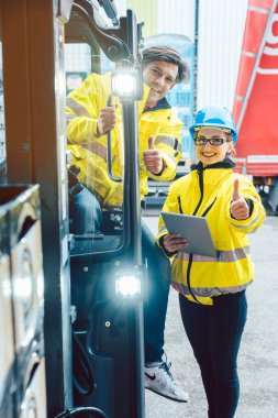 Forklift sürücüsü ve ustabaşı teslimatın nerede yapılacağını tartışıyor