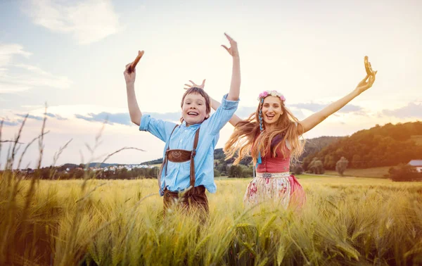 Mère et Fils heureux en Bavière sautant dans une prairie — Photo