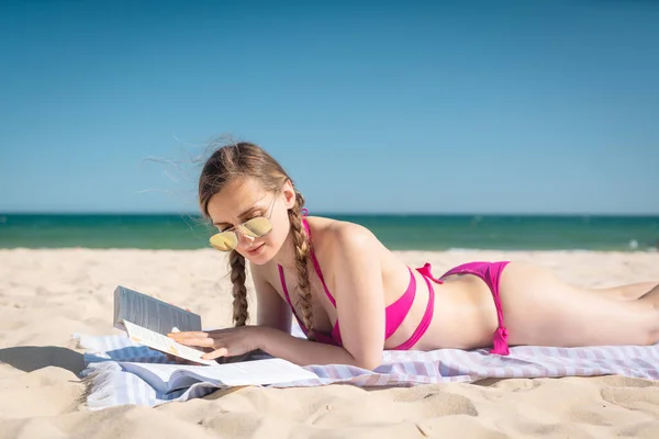 Uczennica na plaży uczy się i czyta na wakacjach — Zdjęcie stockowe