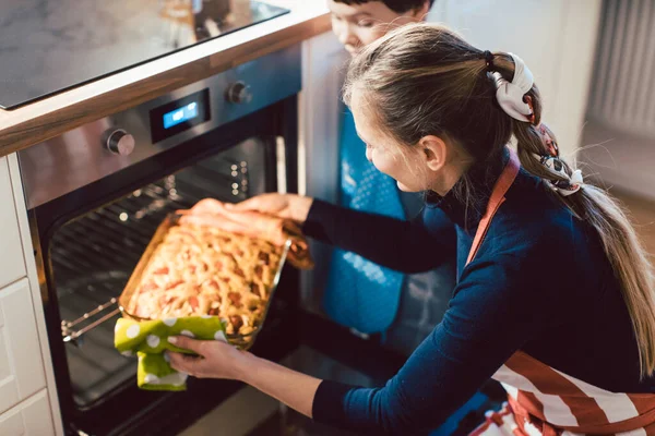 Mor och son bakar paj i ugnen — Stockfoto