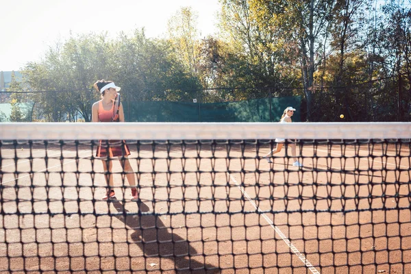 Γυναίκα σε κόκκινο φόρεμα σπορ παίζοντας τένις — Φωτογραφία Αρχείου
