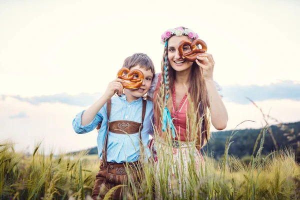 Mother and son in Bavaria looking through pretzels — Stock Photo, Image