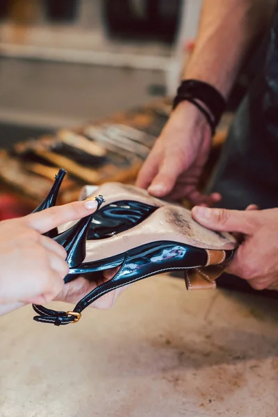 Kunde bringt Schuhe zur Reparatur zum Schuster — Stockfoto