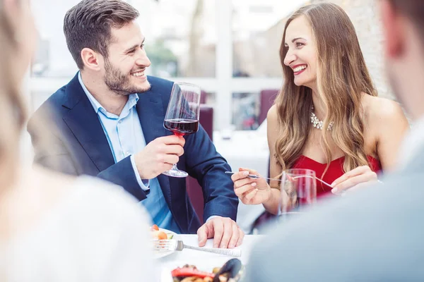 Människor på en italiensk restaurang som dricker vin och äter pasta — Stockfoto