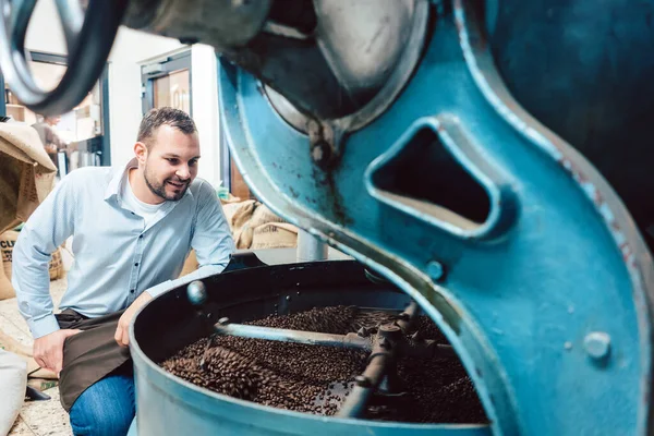Mann betreibt Kaffeeröster in Fabrik — Stockfoto