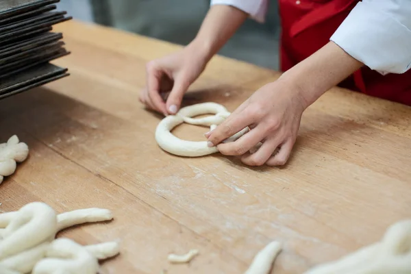 Bäcker formt Brezeln aus Teig — Stockfoto