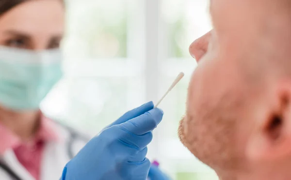 Médico que insere esfregaço no nariz dos doentes para o teste de Covid 19 — Fotografia de Stock