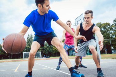 Basketbolcular dışarıda oyun çalışıyor.