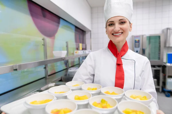 Szakács a kereskedelmi konyhában bemutató tálca desszerttel — Stock Fotó