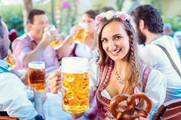 Kvinna rosta till kameran med glas öl i bayerska pub — Stockfoto