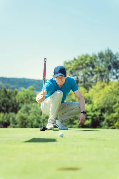 Golf player taking measure to hole in on the green — Stock Photo, Image