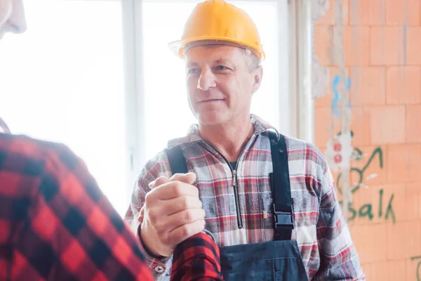 Constructor masculino mayor estrechando la mano con su colega — Foto de Stock