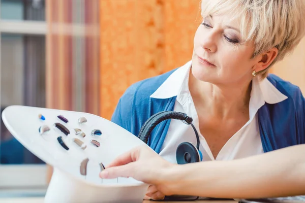 Senior woman with impairment choosing hearing aid — Stock Photo, Image