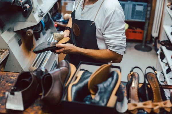 Shoemaker cipőt, hogy javítsa meg egy állvány a műhelyben — Stock Fotó