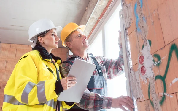 Construcción trabajador masculino e ingeniero que comprueba el panel de ventana —  Fotos de Stock