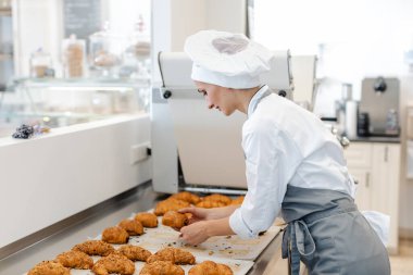 Şekerci kadın hamur işi rolleri ve çikolatalı ekmek yapıyor.