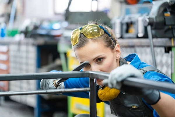 Mujer metalúrgica comprobando la exactitud de su trabajo — Foto de Stock
