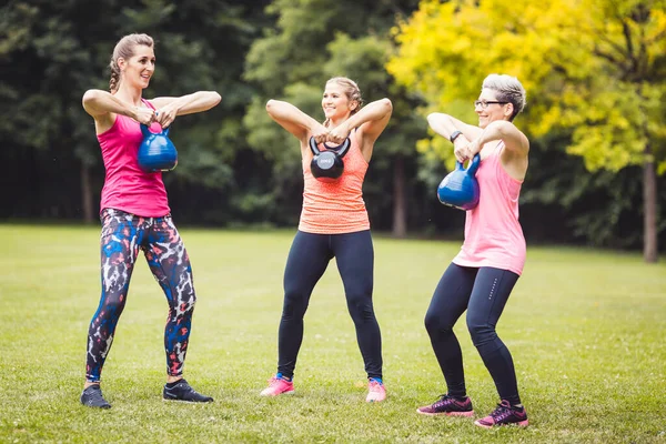 Fitness γυναίκες άσκηση με βραστήρα κουδούνι στο πάρκο — Φωτογραφία Αρχείου