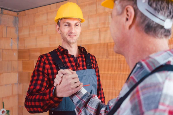 Männlicher Bauingenieur und Bauarbeiter beim Händeschütteln — Stockfoto