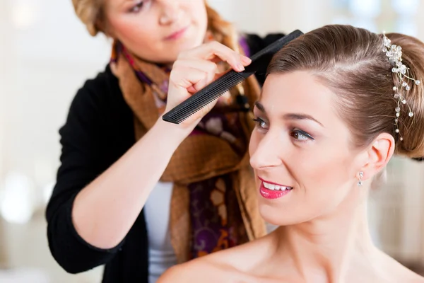 Estilista fijando el peinado de una novia — Foto de Stock