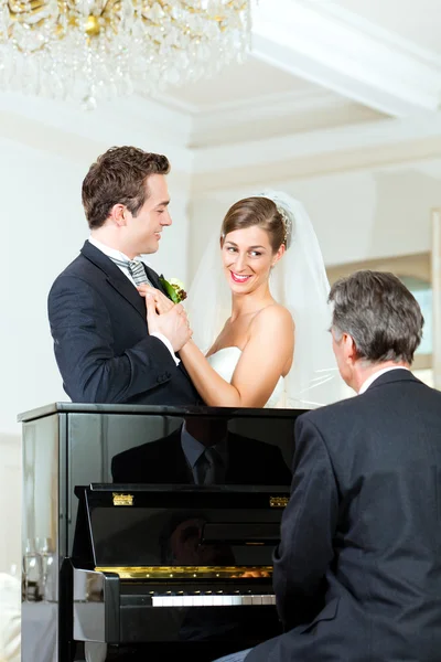 Pareja nupcial frente a un piano — Foto de Stock