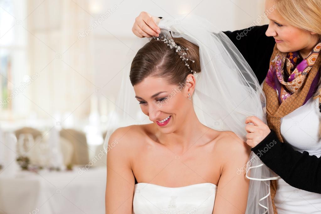 Stylist pinning up a bride's hairstyle