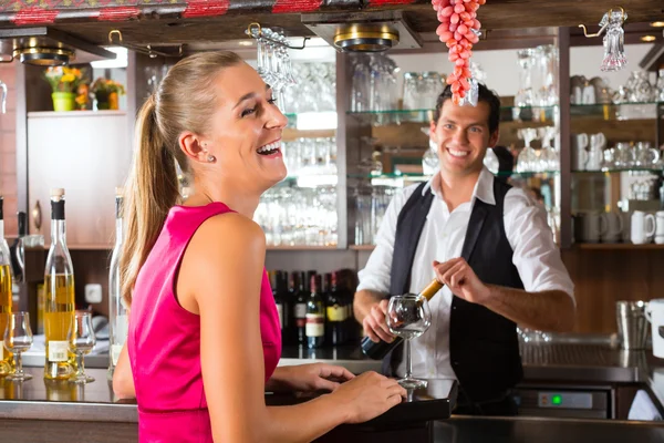 Vrouw bestellen glas wijn op bar — Stockfoto