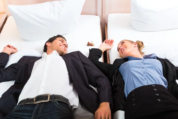 Mladý pár ležící na posteli — Stock fotografie