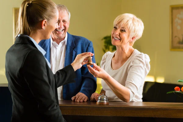 Reception - Guests check in a hotel — Stock Photo, Image