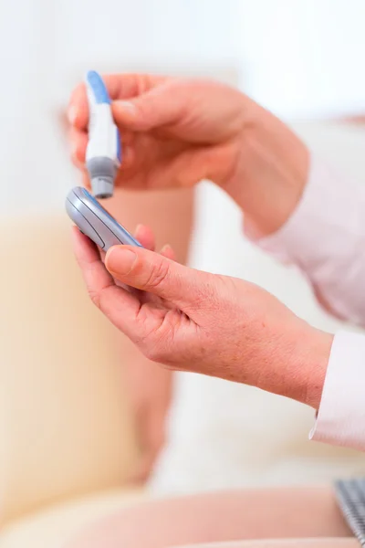 Senior  using blood glucose analyser — Stock Photo, Image