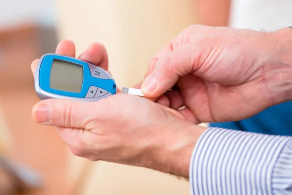 Senior met behulp van bloed glucose-analysator — Stockfoto