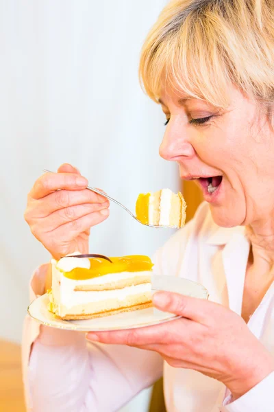 Старша жінка їсть торт — стокове фото