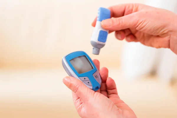 Senior met behulp van bloed glucose-analysator — Stockfoto