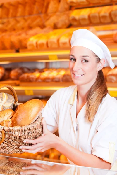 Female baker selling bread in bakery — Stock Photo, Image