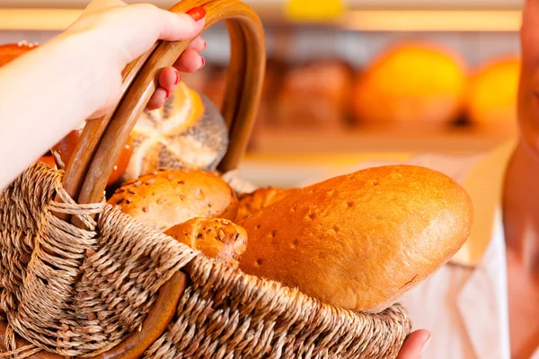 Verkoper met vrouwelijke klant in bakkerij — Stockfoto