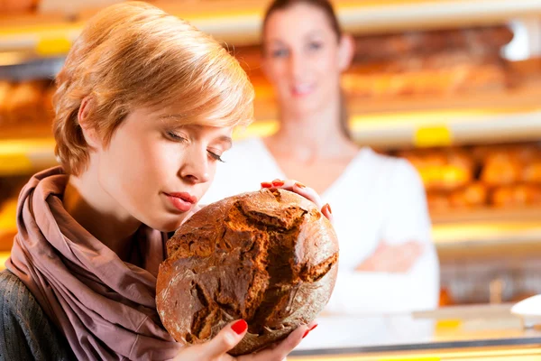 Продавець з жінкою-клієнтом у хлібопекарні — стокове фото