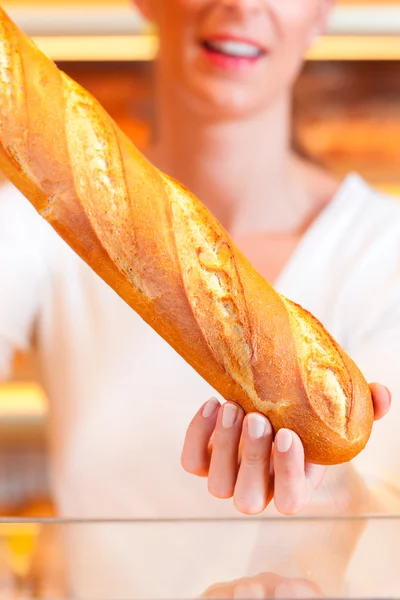 Női baker az ő pékség, baguette — Stock Fotó