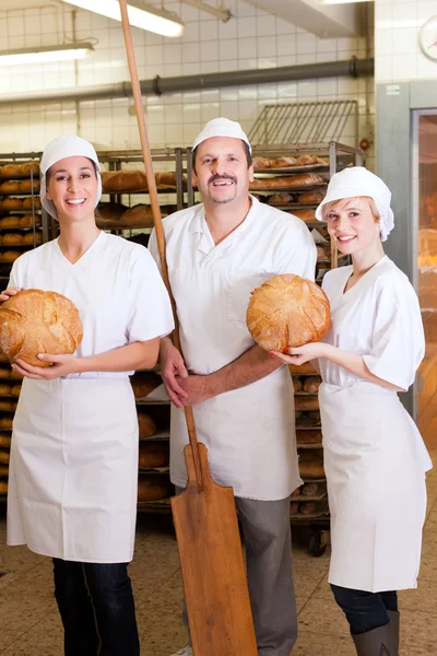 Baker met zijn ploeg in bakkerij — Stockfoto