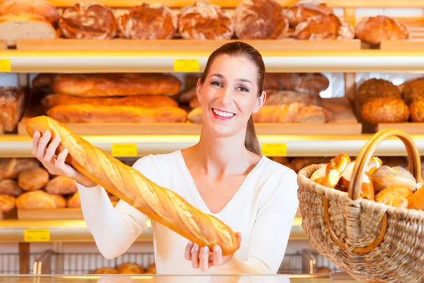 Ženské baker ve své pekárně s bagetou — Stock fotografie