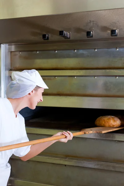 Vrouwelijke baker brood bakken — Stockfoto