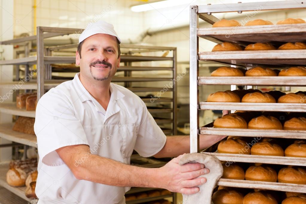 Baker in his bakery baking bread