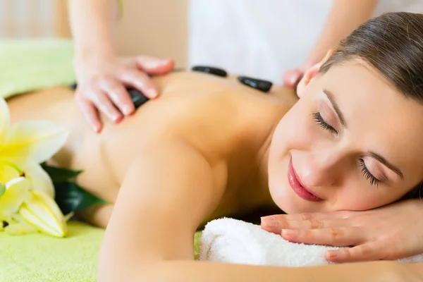 Vrouw met hot stone-massage — Stockfoto