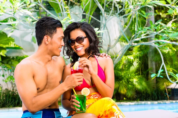 Ασιατικές ζευγάρι πίνοντας κοκτέιλ στην πισίνα — Φωτογραφία Αρχείου