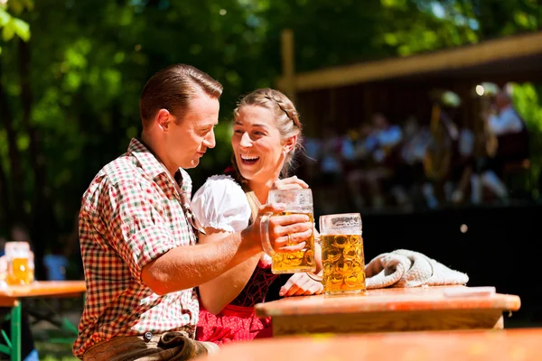 Coppia felice seduta nel giardino della birra — Foto Stock