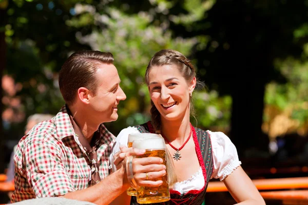 Coppia felice seduta nel giardino della birra — Foto Stock