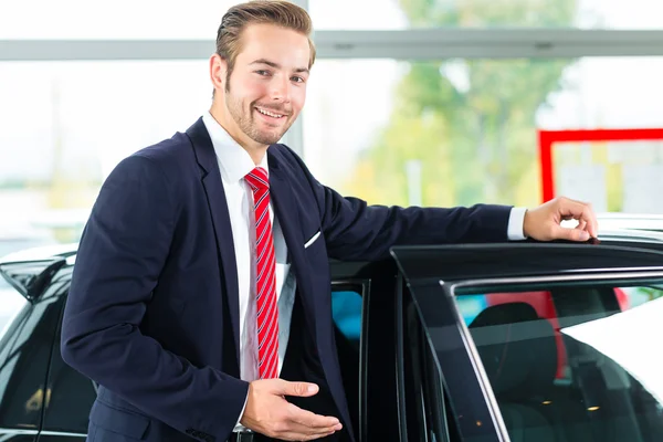 Auto dealer in car dealership — Stock Photo, Image