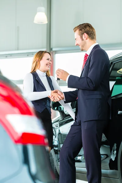 Ung kvinna och säljaren med auto — Stockfoto